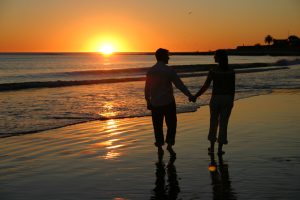 Couple walking on the beach holding hands